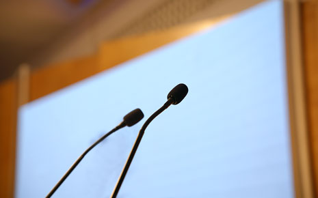 A close-up image of two microphones on a podium